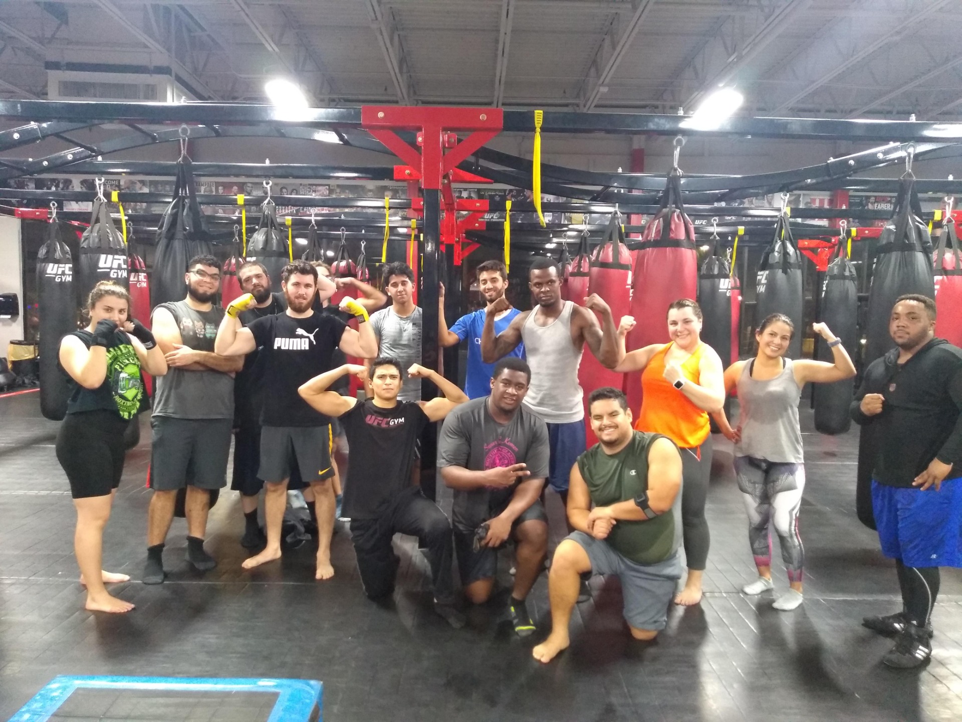 Members training together beside heavy bags